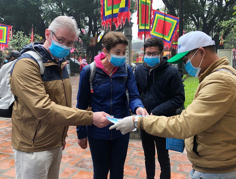 Khách du lịch đeo khẩu trang phòng virus corona, khám phá Thủ đô Hà Nội
